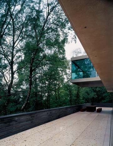The terrace overlooks wooded slopes below the house