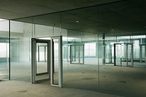 To eliminate visual barriers, glass was used extensively where it was necessary to subdivide the space. Following pages: a view of the first floor studio space. To create a sense of luminosity and spaciousness, the windows reach from the floor to the 10-m-high ceiling