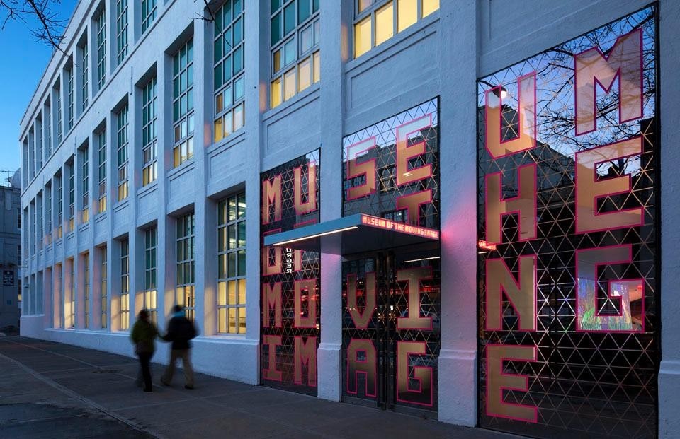 The semi-transparent storefront entrance, with its triangular motif and oversize pink-edged lettering, is the first screen that visitors encounter. ©Peter Aaron. Courtesy of Museum of the Moving Image