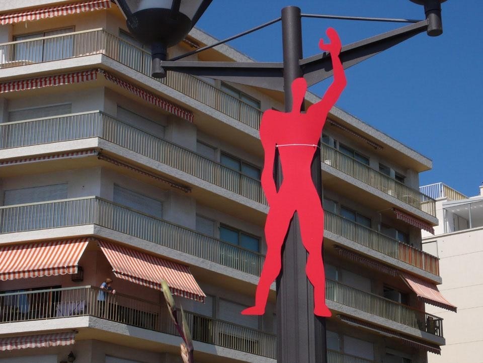 Silhouette of the Corbusian Modulor, the proportions based on the ideal measurements of man, hanging from a lamppost.