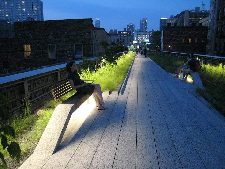 The linear wildflower garden at dusk, with plantings illuminated and benches peeling up from the 12-in. (30.5cm)-wide concrete planks. © Gideon Fink Shapiro.