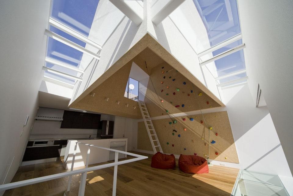 The first floor, flooded with light from above, is strongly characterized by an open space area for climbing, which determines the essence of this house.