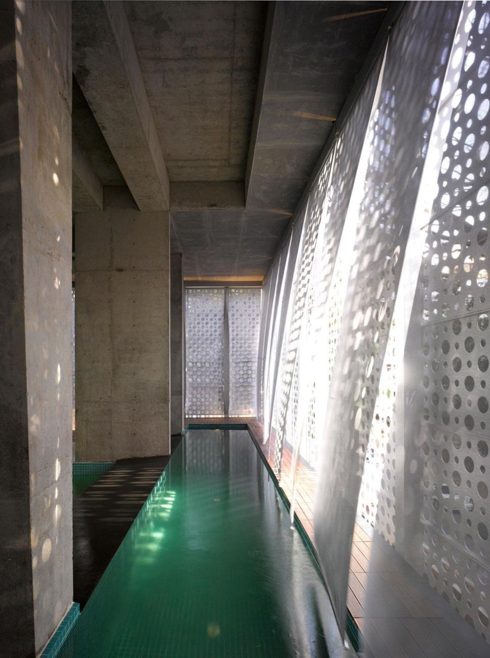 The metal screen allows the light to penetrate inside while assuring privacy in the swimming pool 