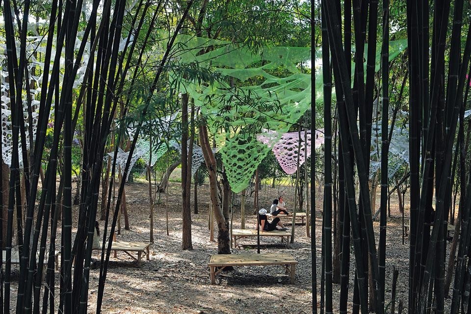 Top: Pitched roofs articulated
on different levels distinguish
the open-air market recently
completed in Bangkok by the
Thai group all(zone). Above: The <em>Act Naturally</em> installation
explores the theme of social
aggregation. A lightweight
sheet of fabric defines a space
in nature, where people can
gather and eat together