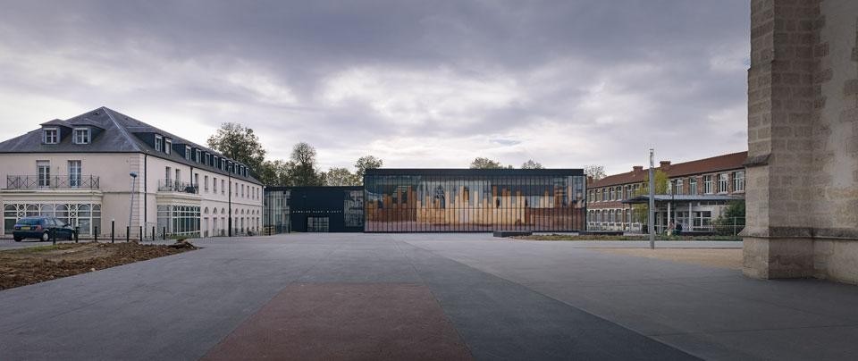 Top: The materiality of its
structure fades into the
ambiguity of the fragmented
images on its glazed skin. Above: The orderly volume of the
new gymnasium looks out
over the central square of
Chelles, recomposing its
surroundings