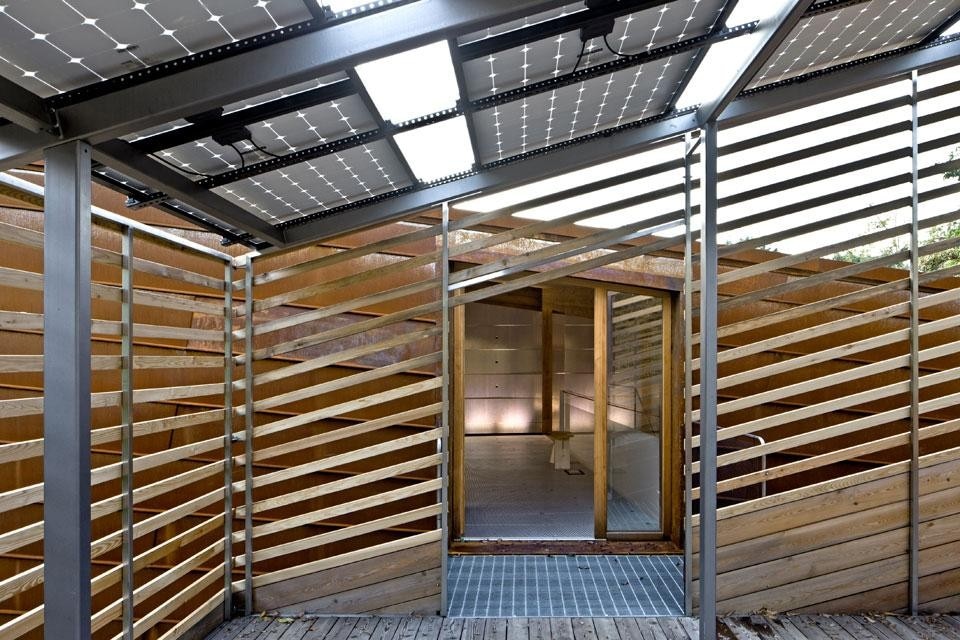 The wood structure supports a sequence of photovoltaic panels