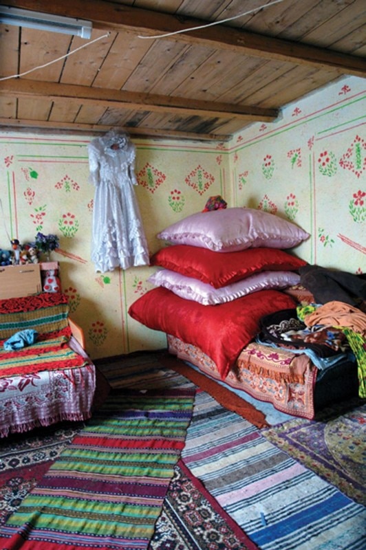 Veresti, Romania. This is not a wealthy Roma home but the family earned enough to have the interior decorated instead of carpets hanging on the walls