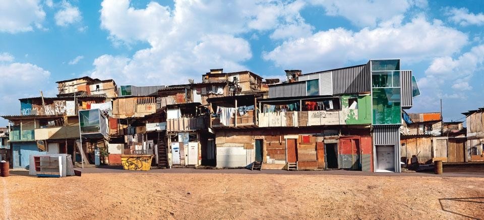 Buraco Quente, colour photo, diasec, 150 x 280 cm, 2004. This photo is part of a cycle of works on the Brazilian favelas, the image of which stands as the symbol of a popular culture that nobody bothers 
to safeguard. Among the elements of the Brazilian shanty-towns, González has inserted geometric and essential architectural modules made of glass and metal in a contemporary style.