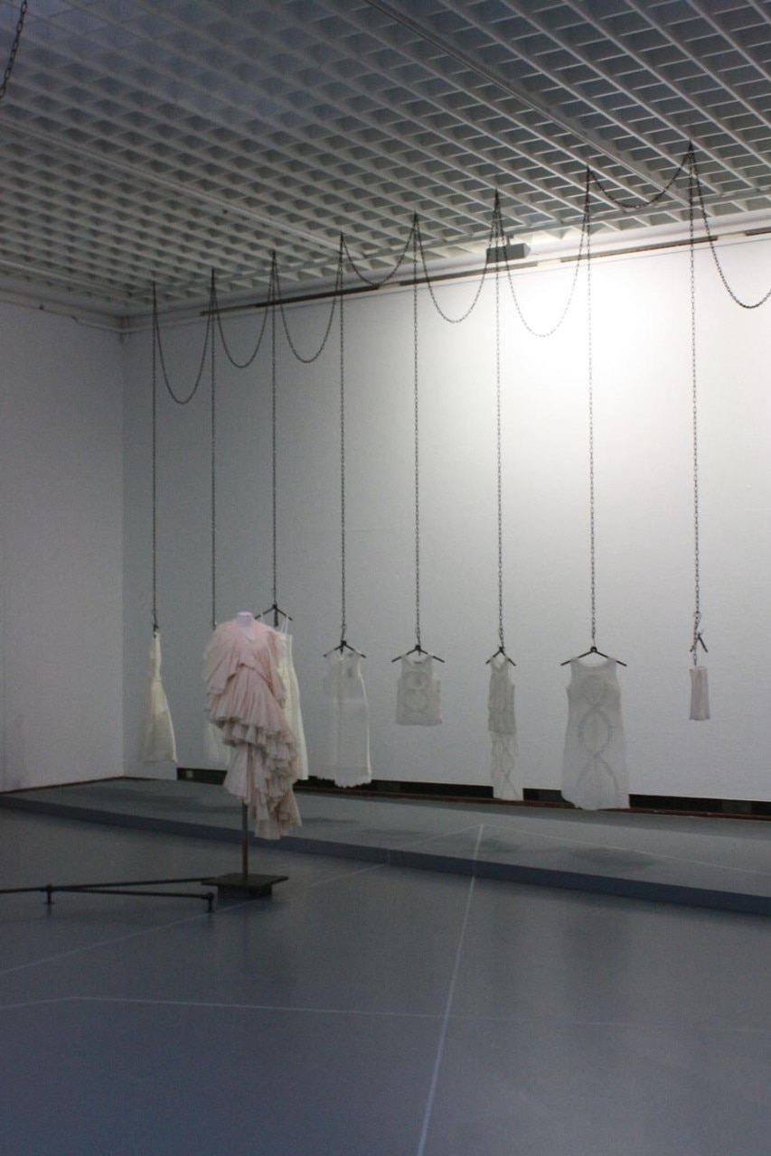 Installation view. In the foreground Comme des Garcons, 1997; in the background, Dirk Van Saerne s/s 1998 Crepe paper dresses
