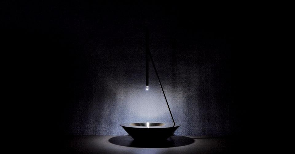 Top: One For All by Yuri Naruse and Jun Inokuma. Above: Dew is an elegant lamp by Vitro driven by a few ounces of water in a small brass bowl. Falling slowly through a pipe with an LED inside, the drops act as a lens and turn the light projected by the LED into a circle of moving light. 