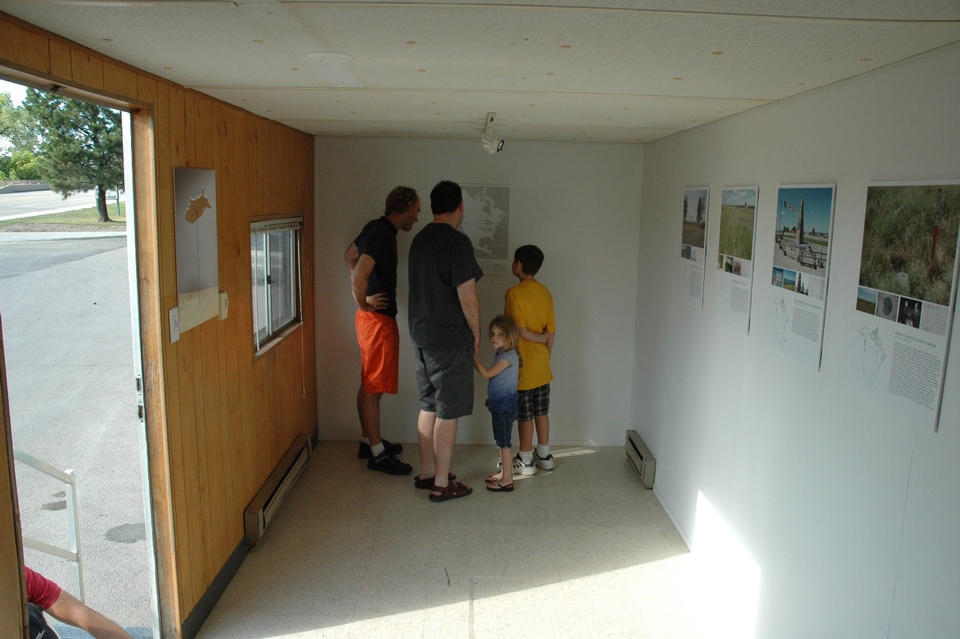 Visitors in the CLUI exhibit unit, at the center of the nation visitors center, Belle Fourche, South Dakota. CLUI Archive Photo.