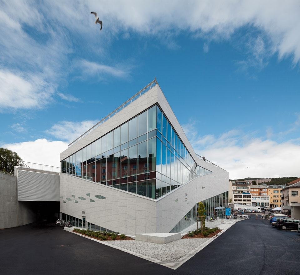 3XN, Plassen Cultural Centre, Molde 2012. Bright granite is used on all exterior surfaces and in the evening is contrasted by the warm red light coming from the concert hall