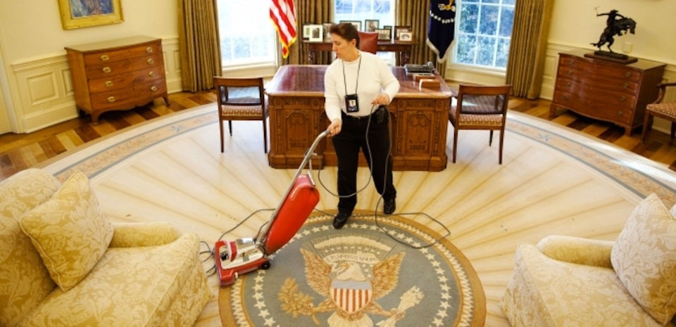 A worker vacuums pine needles after a Christmas tree was removed from the Oval Office, December 30, 2009. (Official White House Photo by Chuck Kennedy)