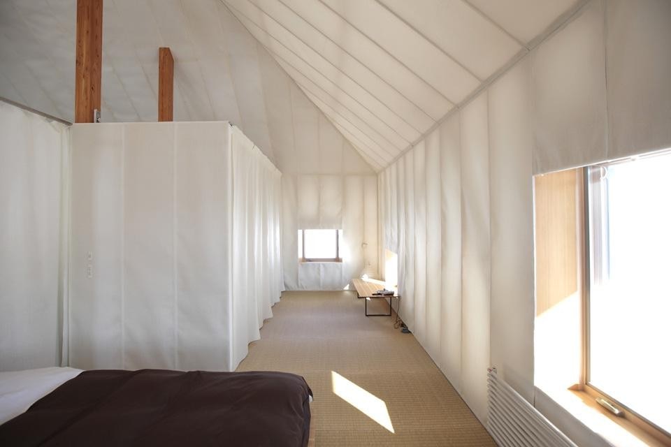 Una camera da letto combinata con uno studio sul lato opposto sono collegati attraverso un soggiorno-spazio pranzo centrale aperto