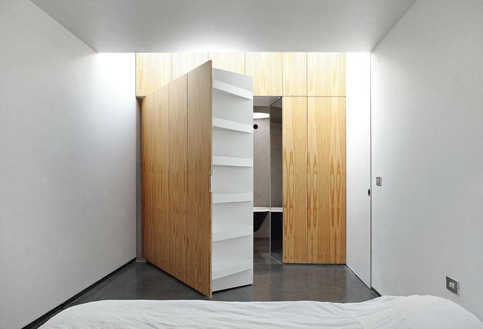 Nella camera da letto padronale, una parete-armadio pivottante introduce a un guardaroba e dà accesso al bagno
