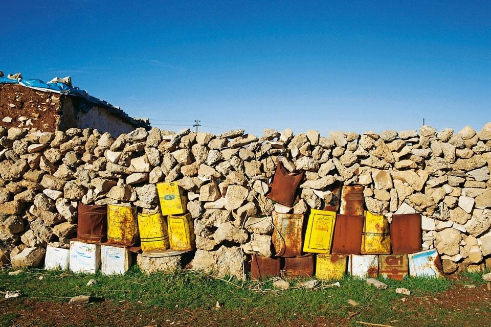 Nel campo idp di Ma’asker Salam, le abitazioni sono state ricavate da vecchie stalle dell’esercito: i bidoni dei rifiuti sono diventati i mattoni di un muro divisorio