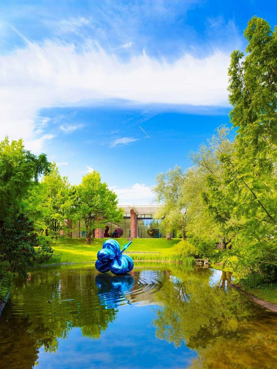 <i>Balloon Flower (Blue)</i> di Jeff Koons si riflette nell'opera di Philippe Parreno, un poetico effetto nell'acqua delle fontane che crea delle ninfee tecnologiche temporanee ed eteree