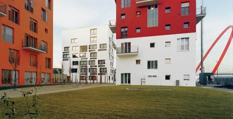 Le architetture di Steidle Architeckten con l’arco della passerella pedonale sullo sfondo