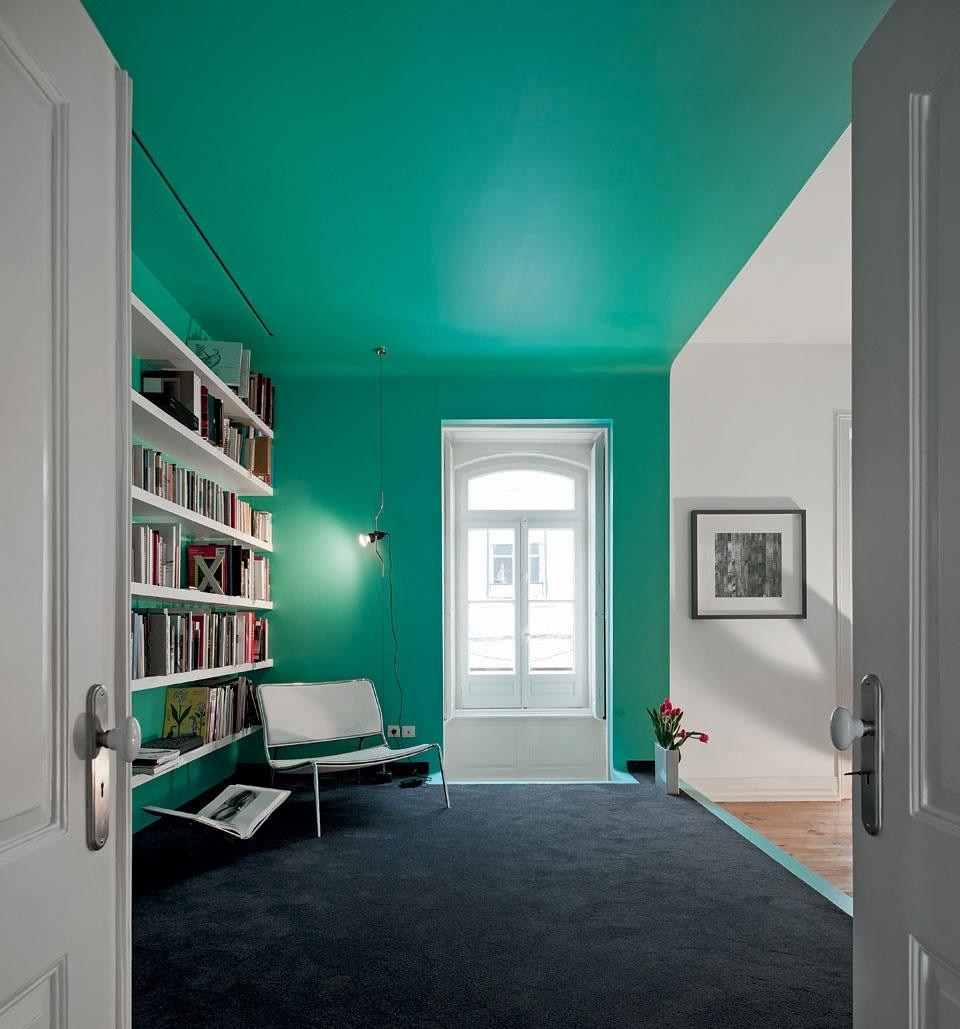 L’intervento nella casa di Torres Vedras, a nord di Lisbona, consiste nell’inserimento di elementi in legno laccato colorato che si staccano nettamente dalla struttura muraria, come nel caso del grande box verde che ospita la biblioteca