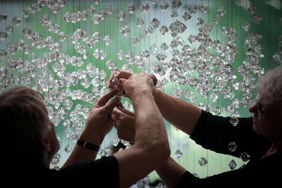 I genitori di Lucas Maassen  mentre appendono i cristalli. Fotografia  di apertura di Robert Andriessen. Qui sopra fotografia di Mike Roelofs