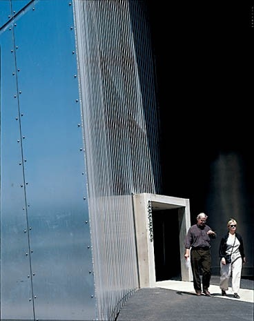 The museum’s entrance is a concrete tube slicing through the metal skin
