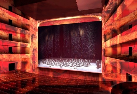 Behind the golden mask, one penetrates into an imposing volume of black marble to discover the main hall. Here the red and gold merge like an immense fresco, whose image has been projected onto the rows, balconies, walls and ceiling. Photo copyright © Perrault Projets S.A. 

