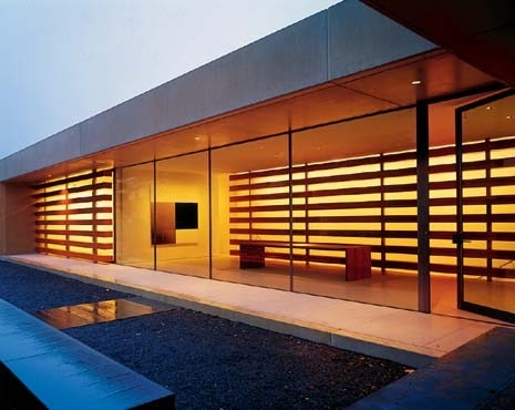 The spacious entrance hall, above left, establishes a generous scale for the house. The master bedroom, cantilevers out, co-opting the surrounding trees