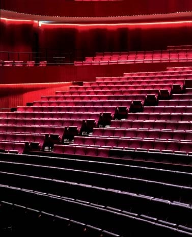 The main hall’s ‘horseshoe’ layout, which can seat up to 1,800 spectators, and the ‘four-square’ stage draw inspiration from the Bayerische Staatsoper in Munich, a design met with much critical acclaim. A mobile ceiling panel allows acoustics to be tailored to the size of the audience. The colour of the seating and the hall’s lining is gradated through 10 different tones from black through red to deep rose; the textile design is by Yoko Ando (NUNO Corp., Tokyo)