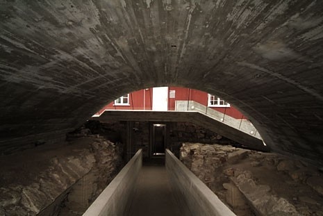 The fairfaced concrete vault of the west wing has been designed to reflect the arch-shaped elements present in the ruins