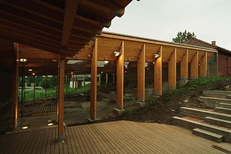 The access route and interior of the north wing. The structure is made from 18-m-long V-sectioned beams, between which narrow glass openings filter the zenithal light