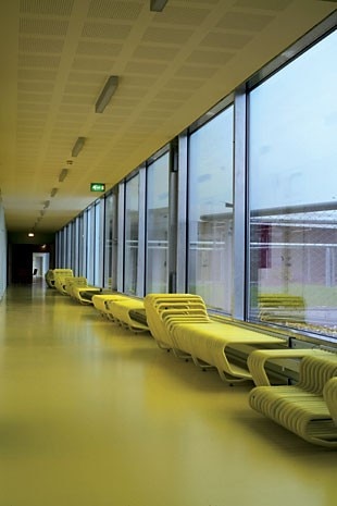 The seating that lines the corridors was also designed by PLOT. A long corridor provides indoor access to the main building of Helsingør Hospital 