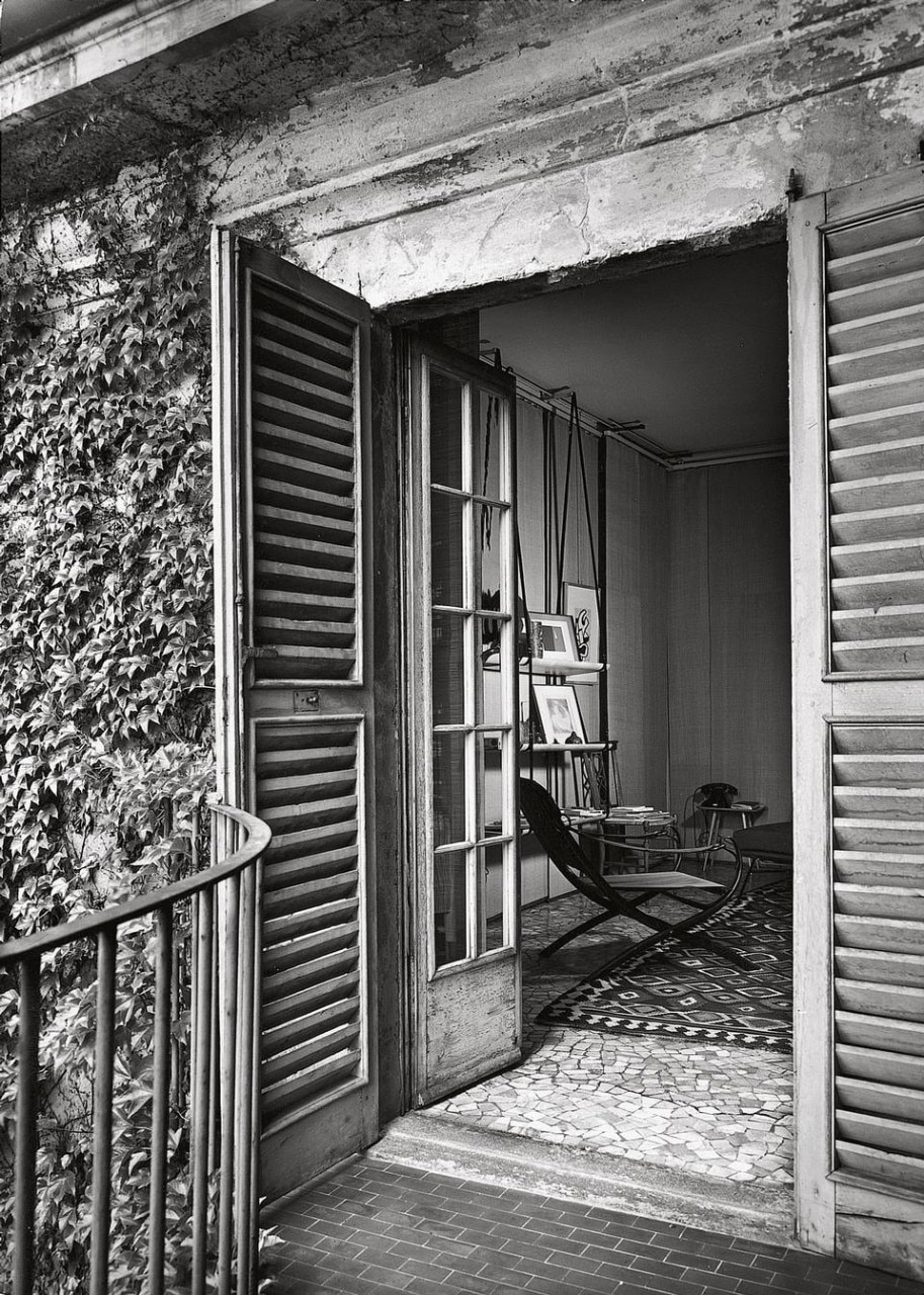 French windows in
the living room, seen
from the small terrace
opening onto a historic
Milanese garden
