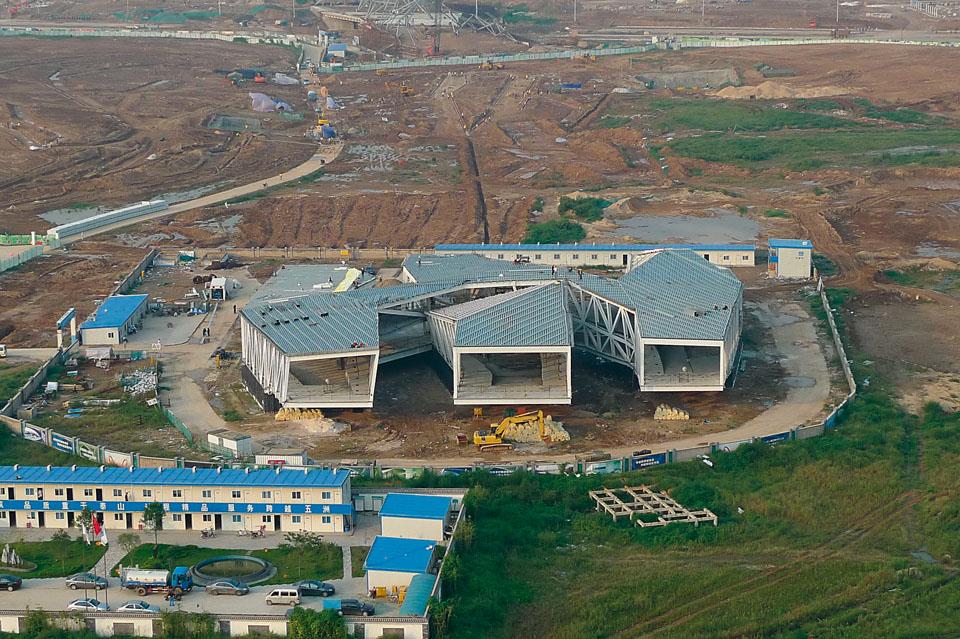 The Exhibition Centre with
its steel grid frame during
the excavation of the ground
in front of it. The cantilever
projects a roof of about
20 m over the lake shore.
The structure rests on a
reinforced concrete base
where the installation spaces
are located.