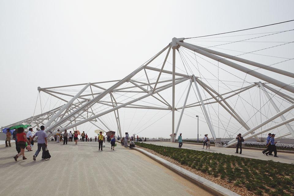 The trellised tensegrity
structure of the Guangyun
Entrance, designed in
collaboration with Arup,
directs visitors towards the
bridge across a main road at
the centre of the exhibition
site. With time, the metal
grid will become covered
with creepers to form a large
green roof.