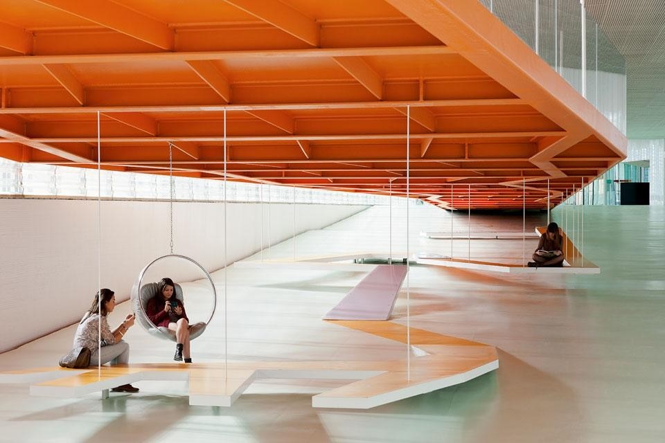 At the end of the main hall, beyond the plexiglass staircases,
the entrances to the large auditorium are sheltered by ridged,
spongy, reef-like concrete walls.