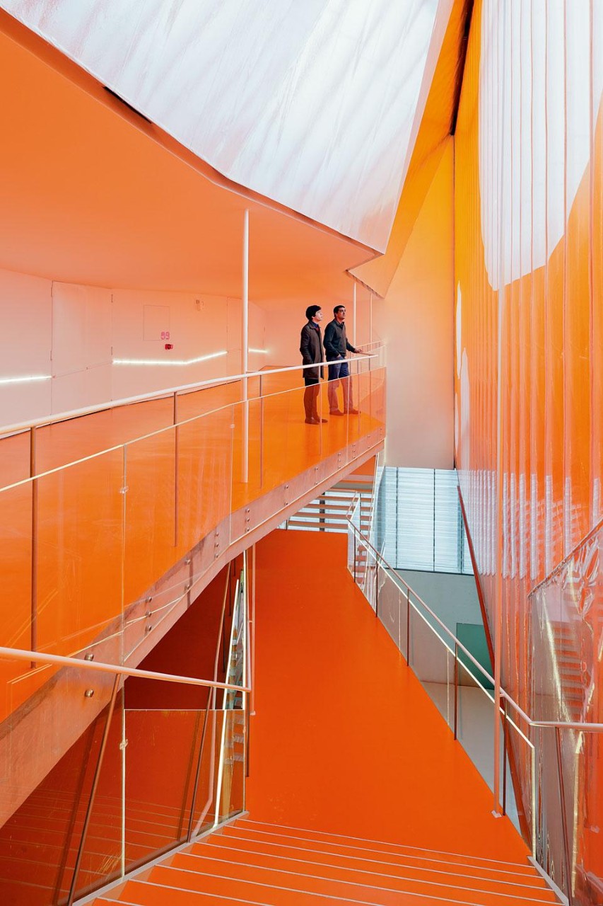 The upper levels are drenched
in a permanent sunset thanks to two 15x60-metre orange coloured
ETFE sheets anchored to a steel frame that create a soft,
billowing intermediate facade. 