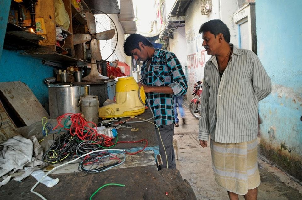 <em>City Makers</em>, Dharavi, 2009. Survey of the district’s
workers. Ramchandra with his
son Lakhan repairing domestic
appliances
