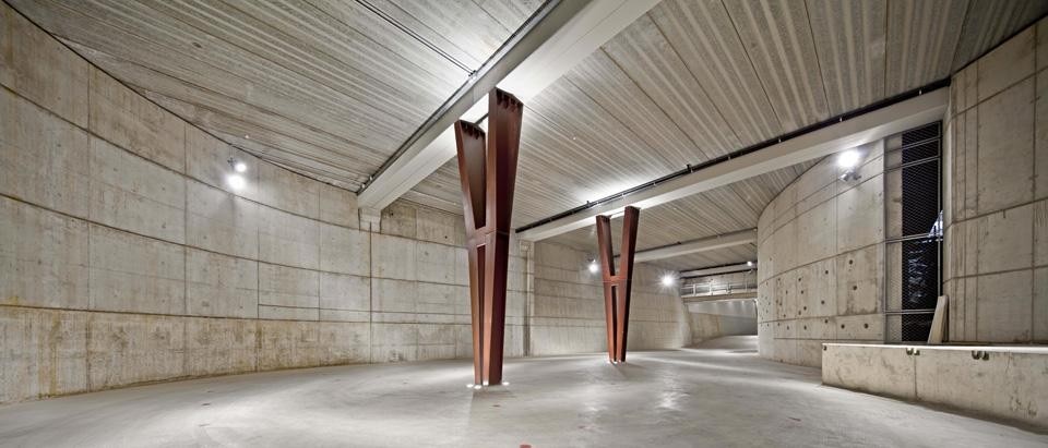 The first body of the building is a traditional space for storage, parking, a showroom and an auditorium, all housed inside
a dark underground floor surrounded by concrete structures