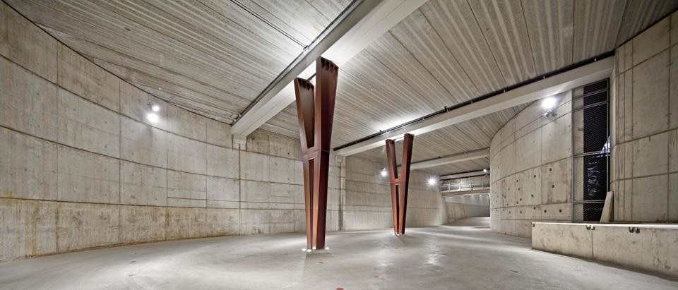 The first body of the building is a traditional space for storage, parking, a showroom and an auditorium, all housed inside
a dark underground floor surrounded by concrete structures The first body of the building is a traditional space for storage, parking, a showroom and an auditorium, all housed inside
a dark underground floor surrounded by concrete structures