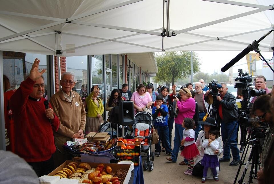 The blessing before the beginning of the trip, in between video cameras, fruit crates and bags piled up in the sidewalk
