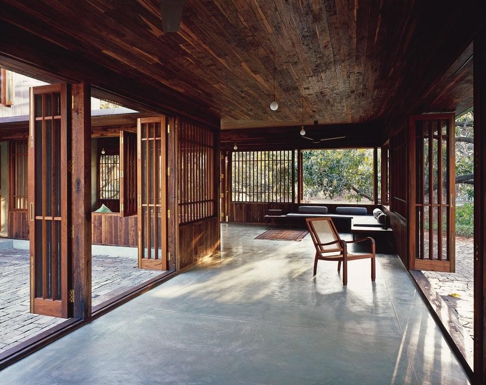 The Copper House II is located in a rural area in the Mumbai hinterland. Surrounded by a wood of mango trees, it opens onto the garden through a portico delimited by a teak wood grille: a typical local feature. Opposite page: the ground level’s floors and walls are faced with a coat of coloured cement