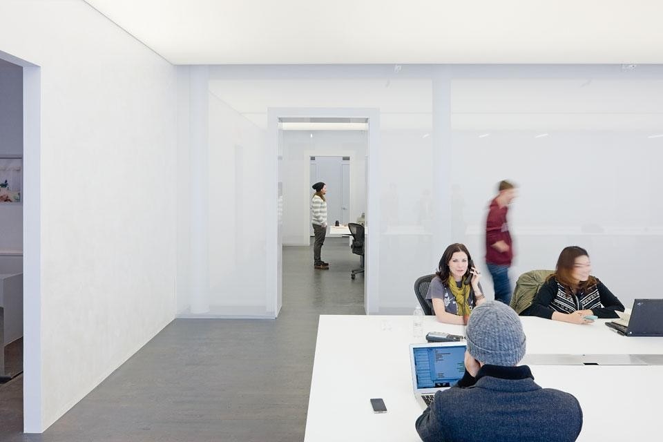 The Logan offices in SoHo, New York. The false ceiling in PVC
reflects natural light without
casting shadows. The end
section of the continuous
table is separated from the
rest of the room by a glazed
wall to create an acoustically
insulated space