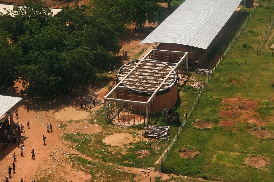 Top and above: The Gando campus library
acts as a hinge between
the elementary school and
its extension. The effect of
fragmented light is achieved
by inserting handmade
bottomless terracotta pots
into the roof slab. The
latter is then protected by a
second roofing in translucent
polycarbonate