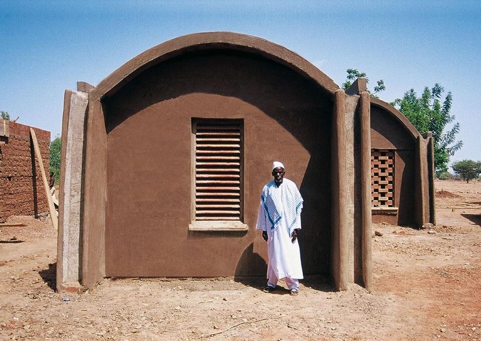 In Gando, Kéré has also
built six cottages with barrel
roofs to accommodate
the teaching staff and
their families. Standing
in a crescent on the south
boundary of the school
premises, their walls are 40
cm thick and composed of
earth blocks erected on stone
foundations