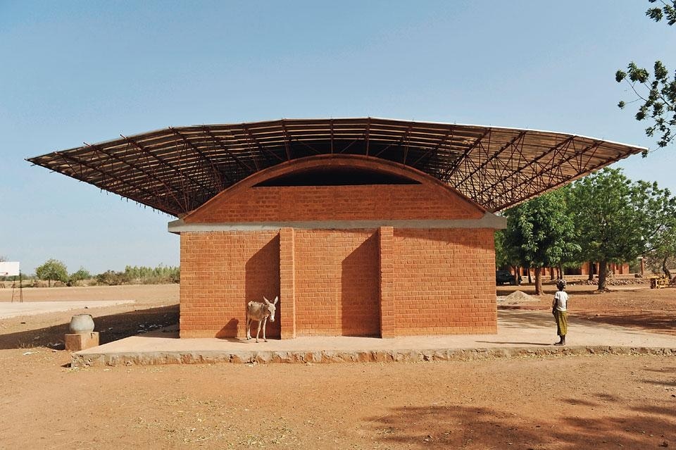 The building that started
the Gando campus is an
elementary school (not
shown). Completed in 2001,
it immediately needed to be
enlarged; above: the new
extension. This construction
has a double roof: a barrelvaulted
brick slab and a
metal overhang, whose
ramified structure suggests
that of a tree