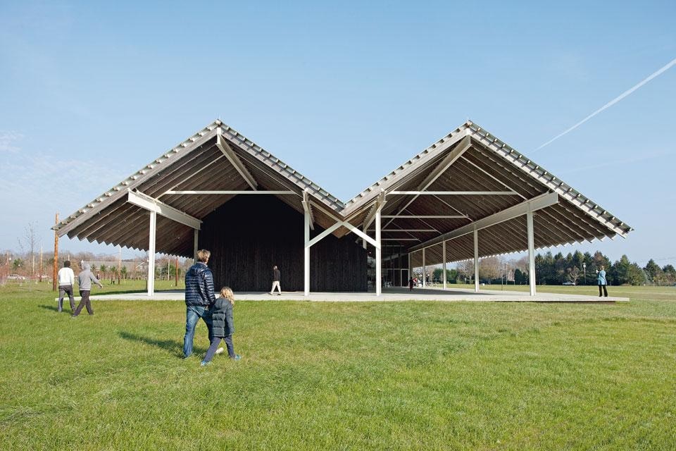 The
porch with its posts, beams
and trusses accommodates an
open-air bar. Only when close
to the side elevation does
one notice that the building is
formed by two main volumes