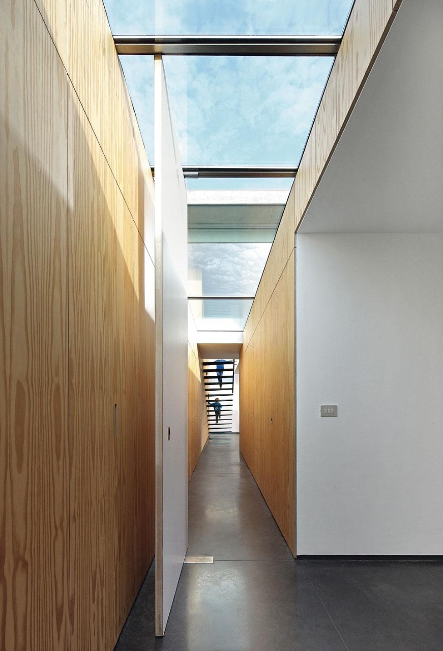 Built-in wall cabinets run
the length of the corridor
on the lower level, which is
illuminated by a skylight