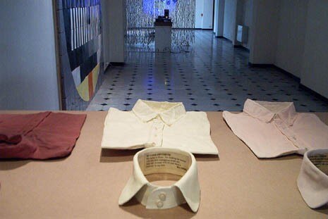 Iké Udé, “Beyond Decorum”. This is a series of works commenced in 2000 in which the artist placed quite audacious messages inside some elegant, well-tailored garments, intending to show the dual nature of human beings. The same was done with ceramic collars and white coats      