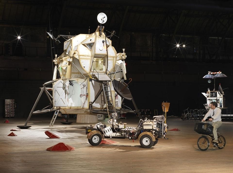Installation view of the <em>Landing Excursion Module (LEM)</em>, <em>Mars
Excursion Roving Vehicle (MERV)</em>, and Tom Sachs on <em>WAR
Bike</em> in <em>Space Program: Mars</em>. Photo by Genevieve
Hanson