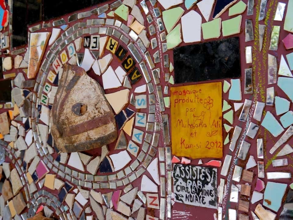 The Ker Thiossane medialab celebrates its tenth anniversary with a large mural by artists Muhsana Ali and Kan Sy, composed of mirrors and objects in the traditional Senegalese <em>sous-verres</em> technique. Photo by Susana Moliner